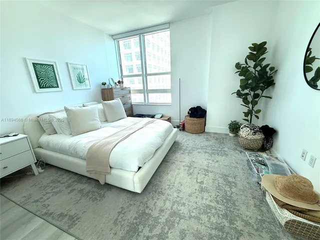 a bedroom with a bed and a potted plant