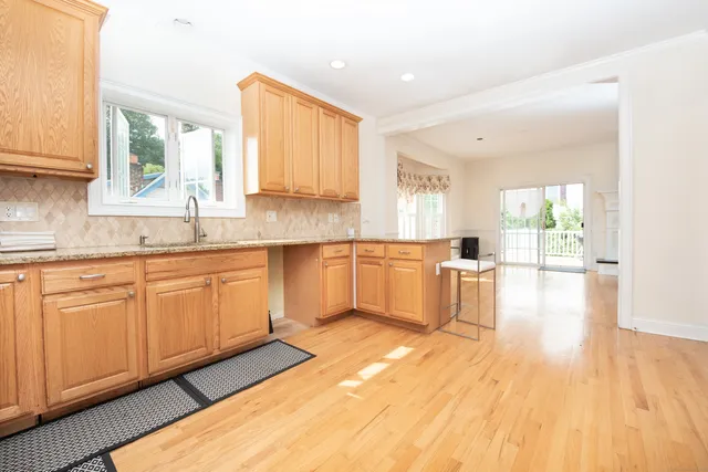 a large kitchen with cabinets wooden floor and stainless steel appliances