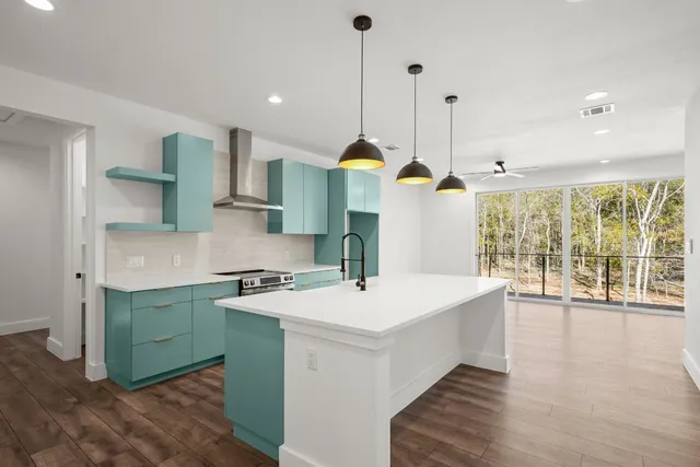 a large kitchen with kitchen island a stove a counter top space a sink and wooden floor