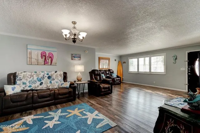 a living room with furniture chandelier and a window
