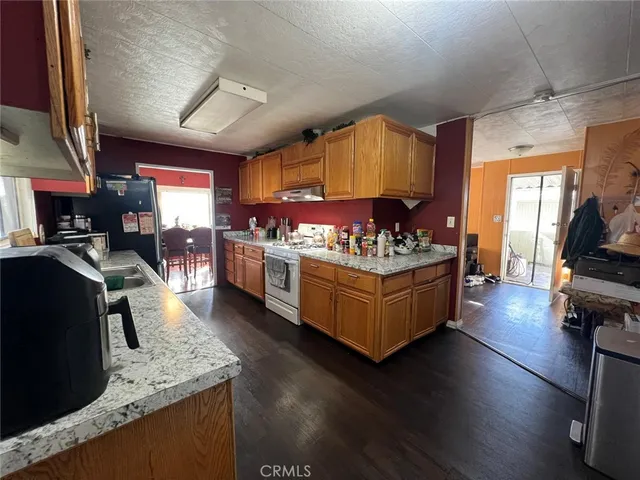 a kitchen with stainless steel appliances granite countertop a stove a sink dishwasher and a dining table with cabinets