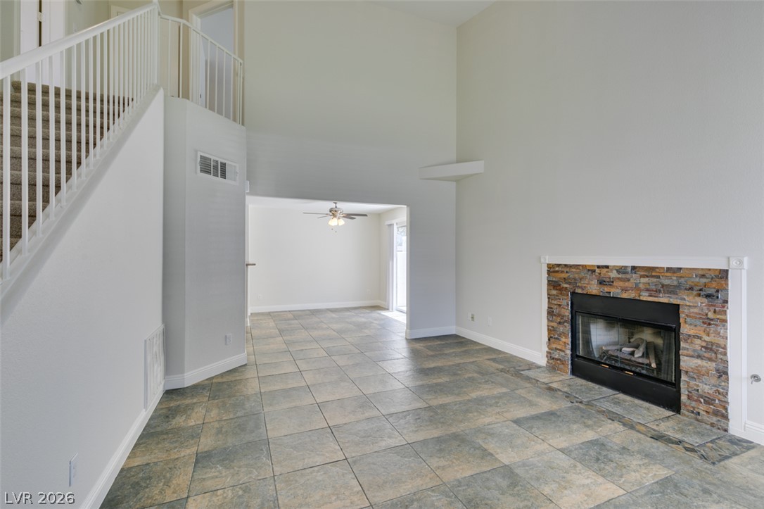 200 Luninborg Street Henderson, NV 89074 - Photo 28 of 40 A spacious living area features high ceilings, a stacked stone fireplace, and durable tile flooring.