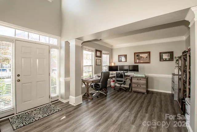 a work room with furniture a wooden floor and windows