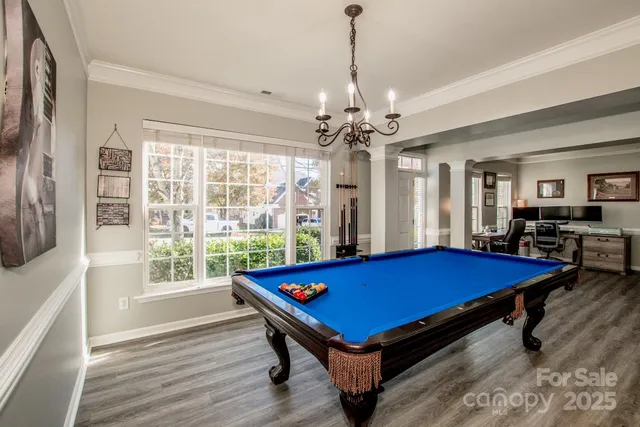 a room with pool table and windows