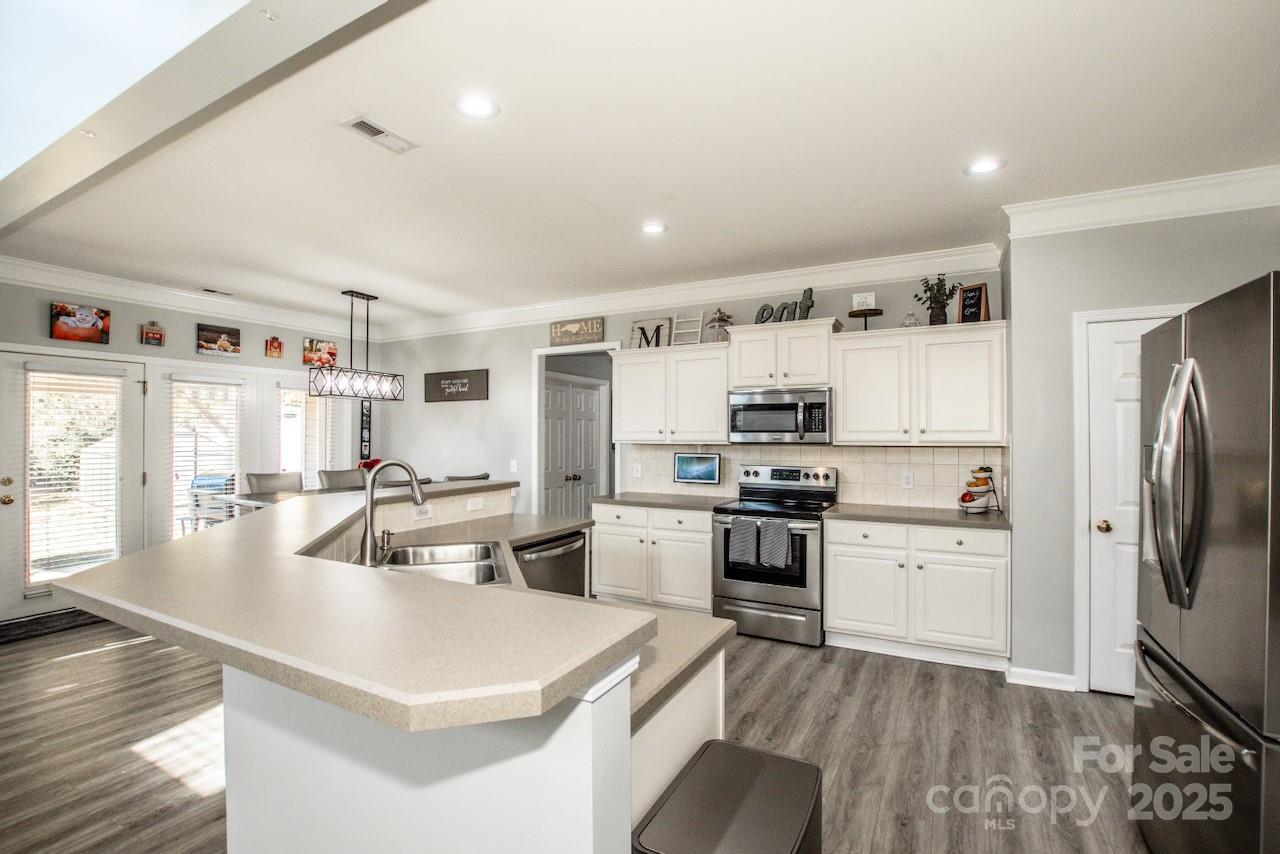 182 Harris Farm Road Mooresville, NC 28115 - Photo 18 of 44 a kitchen with refrigerator a stove and cabinets