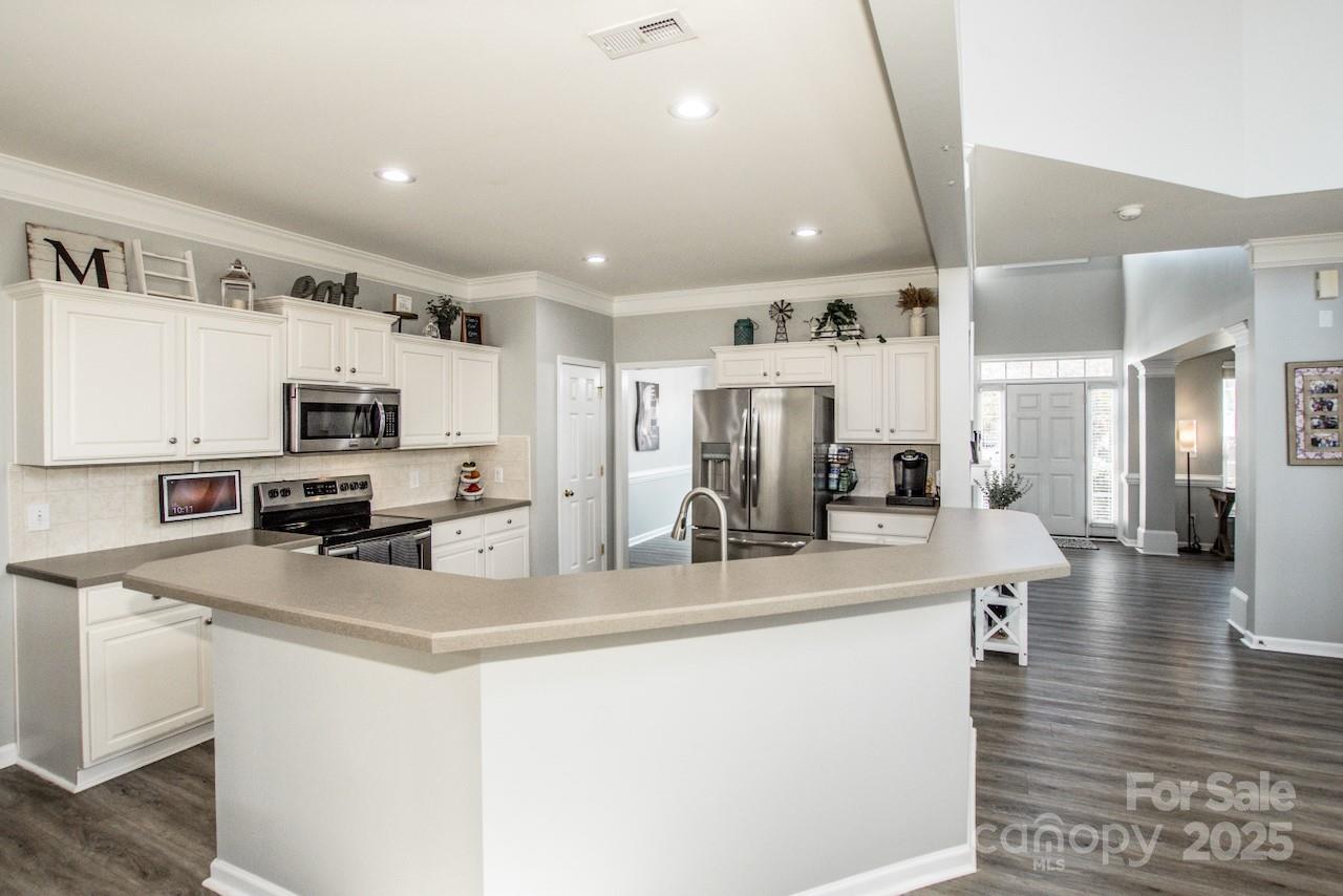 182 Harris Farm Road Mooresville, NC 28115 - Photo 20 of 44 a kitchen with stainless steel appliances a refrigerator sink stove microwave and cabinets