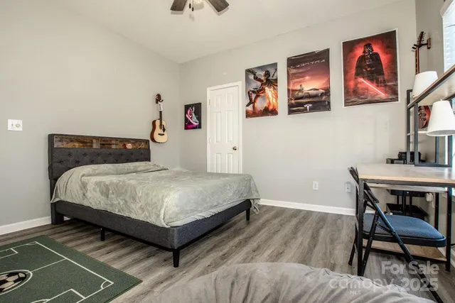a bedroom with a bed and paintings on wall