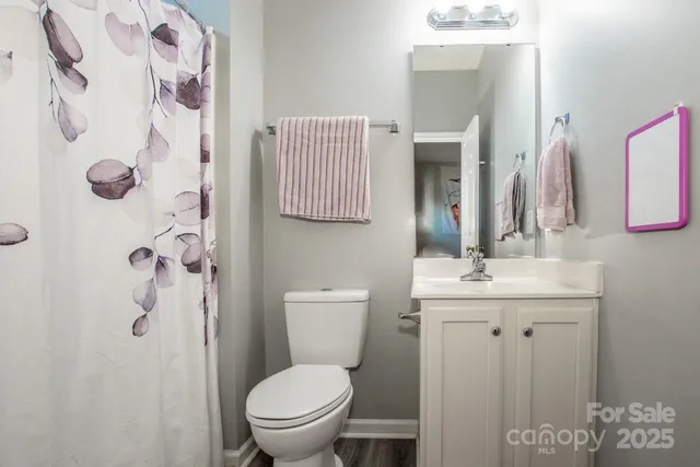 a bathroom with a granite countertop toilet sink and mirror