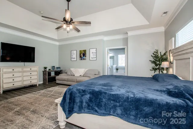 a spacious bedroom with a bed and a flat screen tv