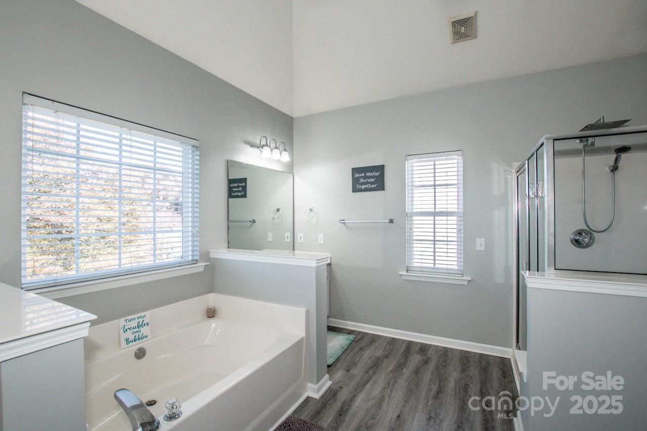 182 Harris Farm Road Mooresville, NC 28115 - Photo 36 of 44 a bathroom with a bathtub a shower a sink and a window