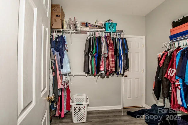 a view of walk in closet with clothes and shoes