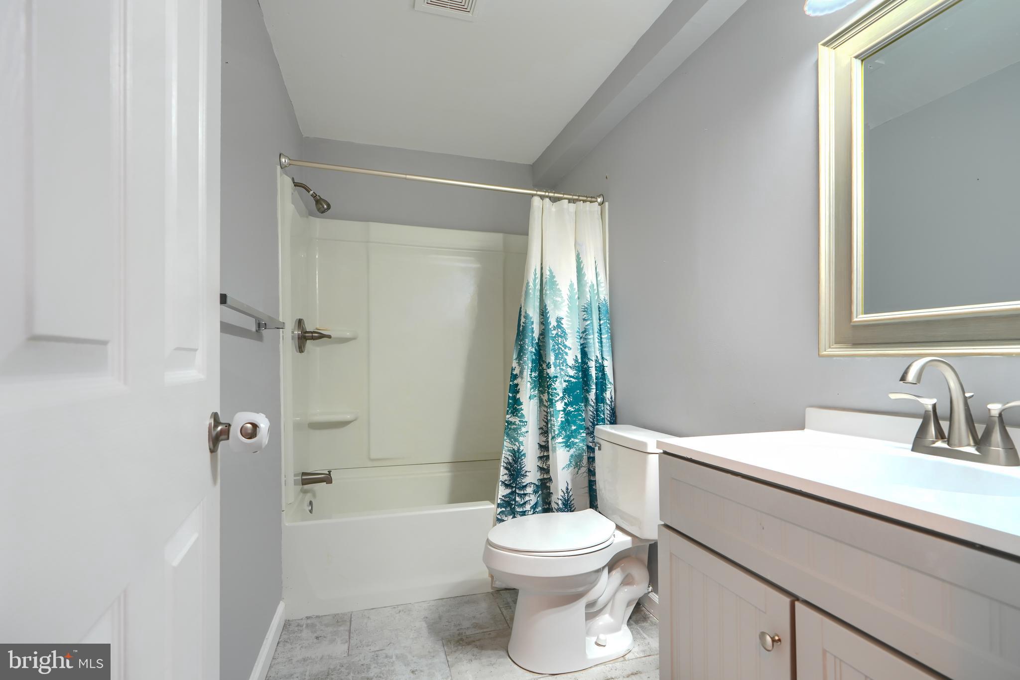1713 Sea Pine Circle Severn, MD 21144 - Photo 29 of 33 a bathroom with a sink a toilet a mirror a bathtub and shower