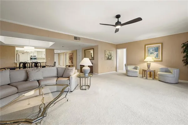 a living room with furniture and a ceiling fan