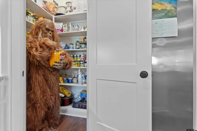 a large kitchen with stainless steel appliances a stove a sink a oven and a dining table with wooden floor