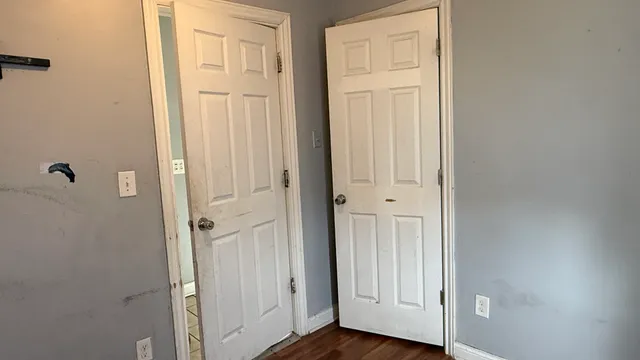 a view of a room with wooden floor and mirror