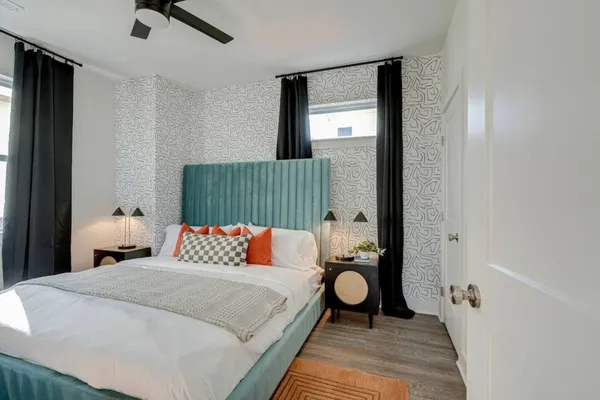 a bedroom with a bed and painting on the wall