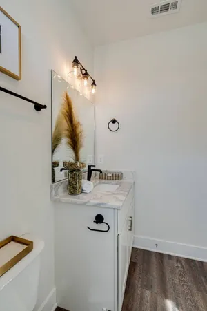 a bathroom with a granite countertop sink a toilet and shower