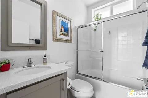 a view of an empty room with window and bathroom