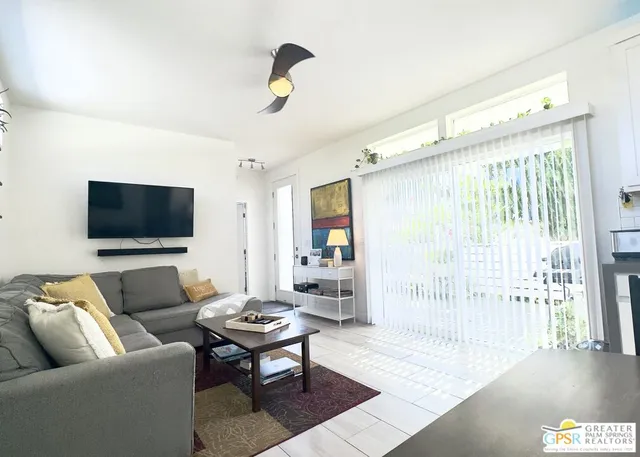 a living room with furniture a dining table and paintings on the wall