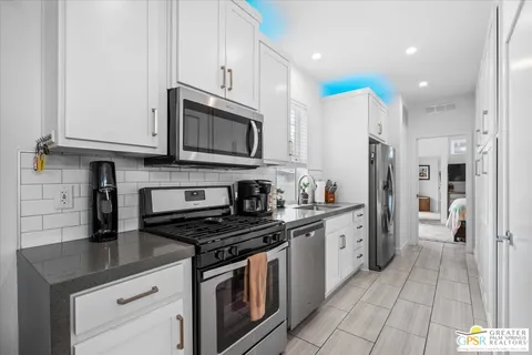 a kitchen with stainless steel appliances a sink a stove and a window