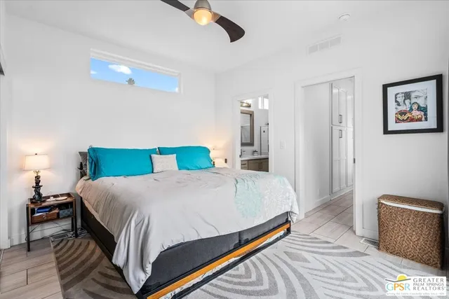 a bed sitting in a spacious bedroom next to a window