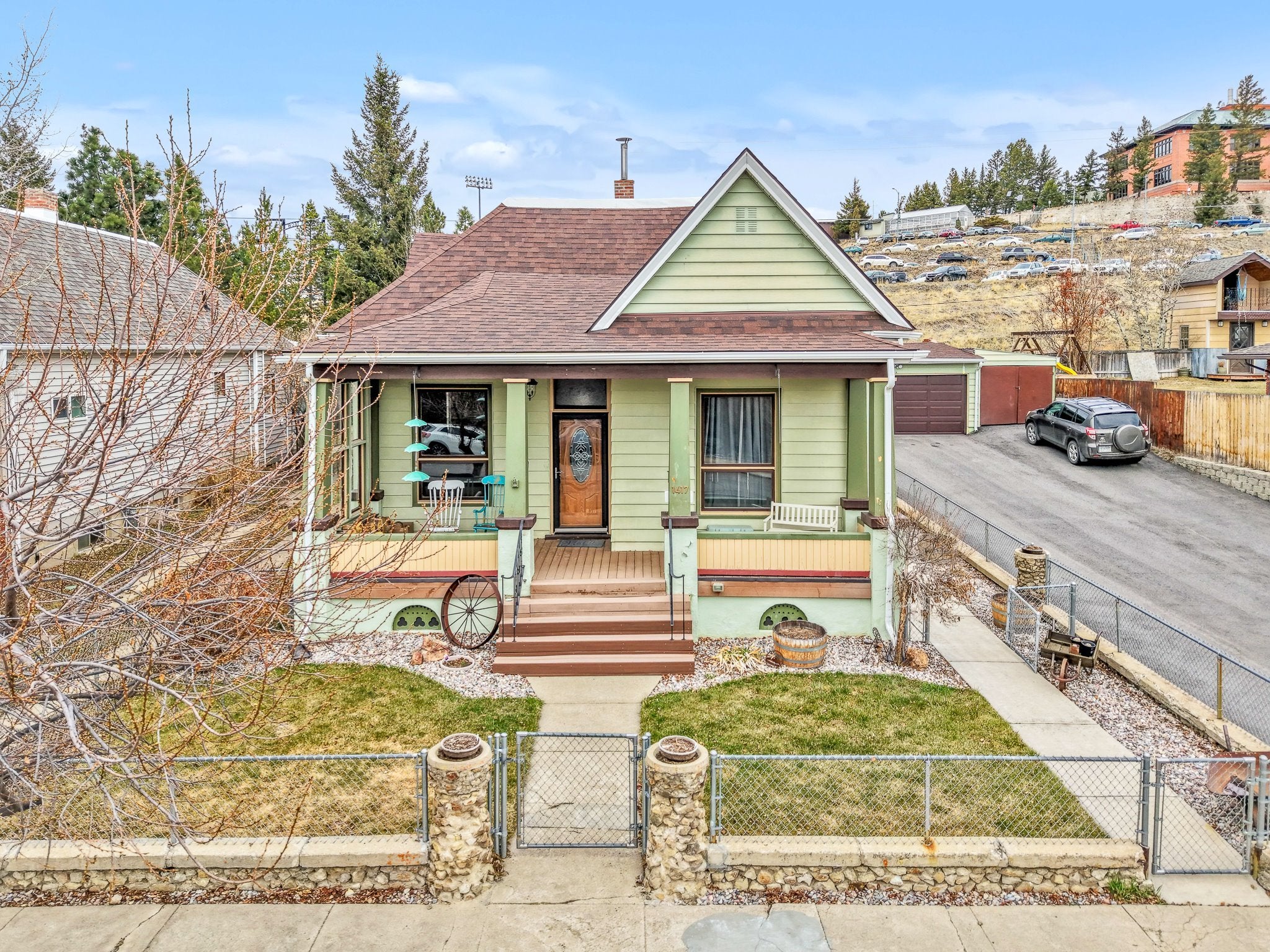 1417 West Diamond Street Butte, MT 59701 - Photo 1 of 1 View of front of property with a front yard, a shingled roof, a porch, a fenced front yard, and a gate