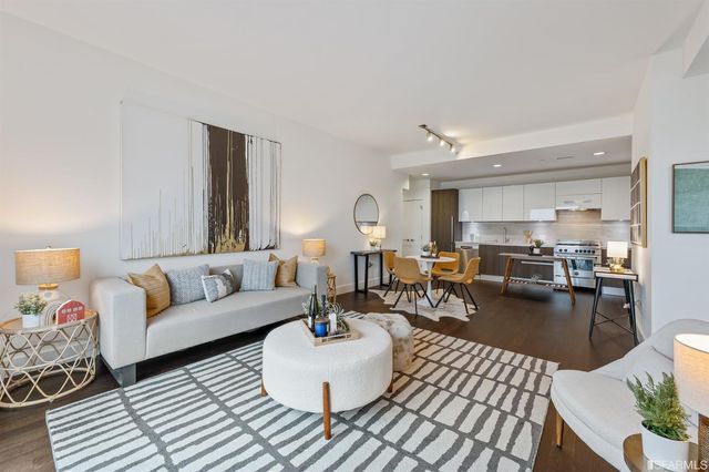 a living room with furniture and view of kitchen