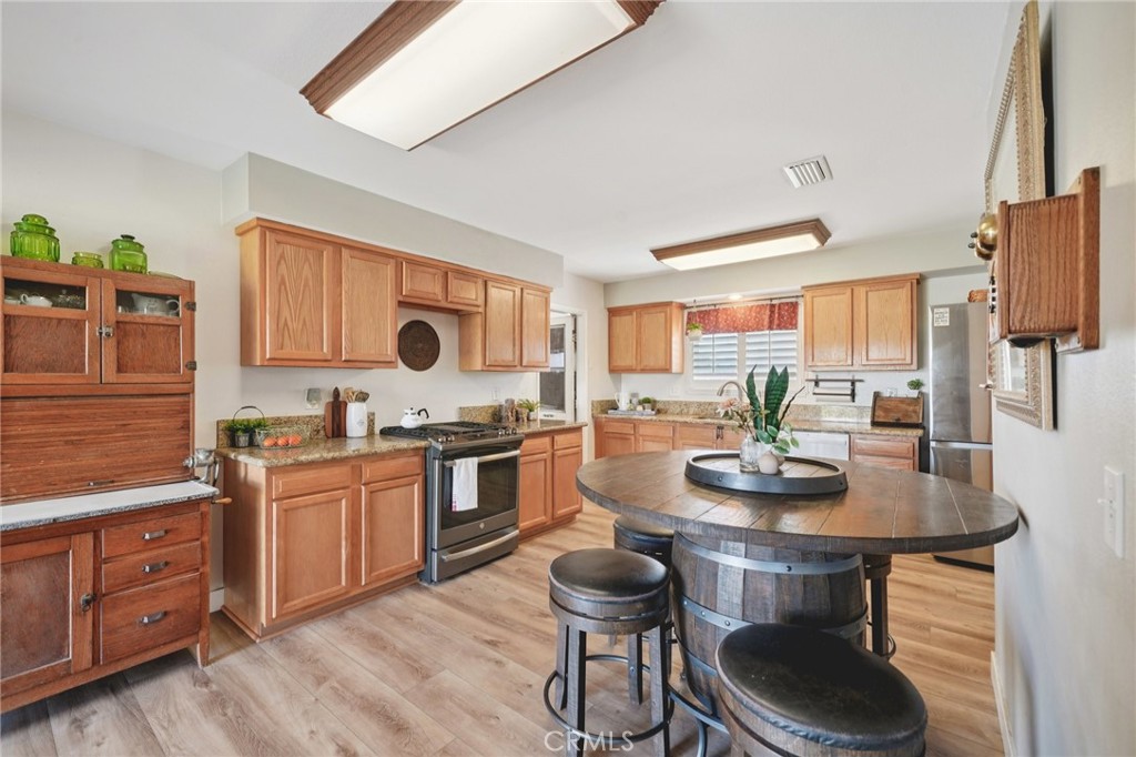 2821 Riding Ring Road Norco, CA 92860 - Photo 12 of 54 a kitchen with stainless steel appliances kitchen island granite countertop a stove a sink and a refrigerator