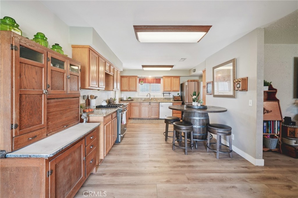 2821 Riding Ring Road Norco, CA 92860 - Photo 13 of 54 a kitchen with stainless steel appliances kitchen island granite countertop a table chairs and a refrigerator