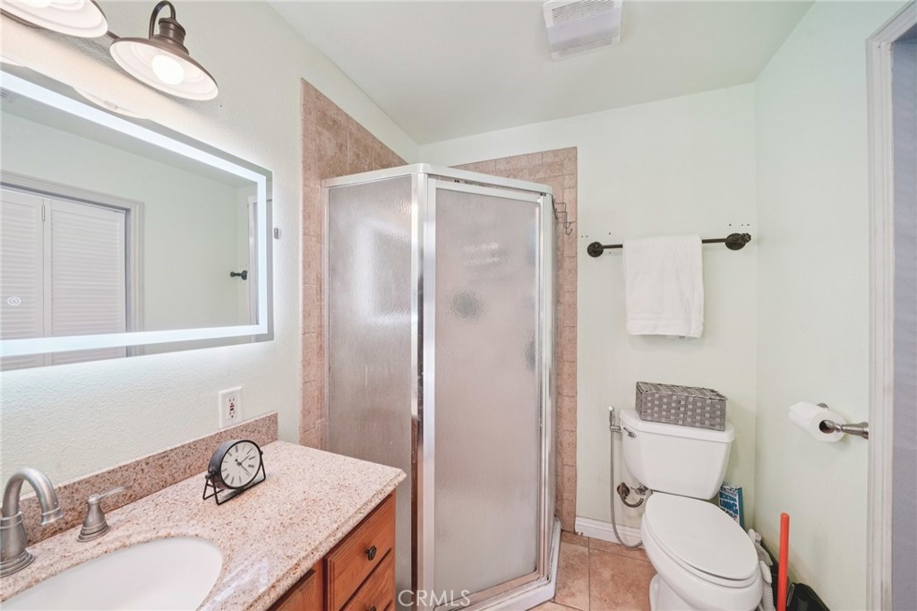 2821 Riding Ring Road Norco, CA 92860 - Photo 35 of 54 a bathroom with a granite countertop sink toilet a mirror and shower