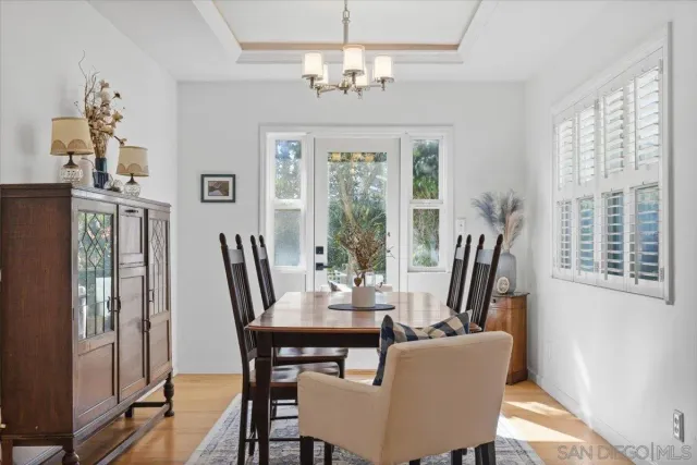 a dining room with furniture a chandelier and wooden floor