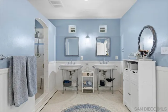 a en suite bathroom with a double vanity sink and a mirror