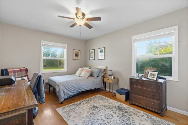 a bedroom with a bed and wooden floor