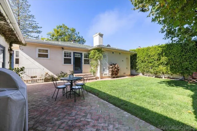 a view of a house with backyard and a sitting area
