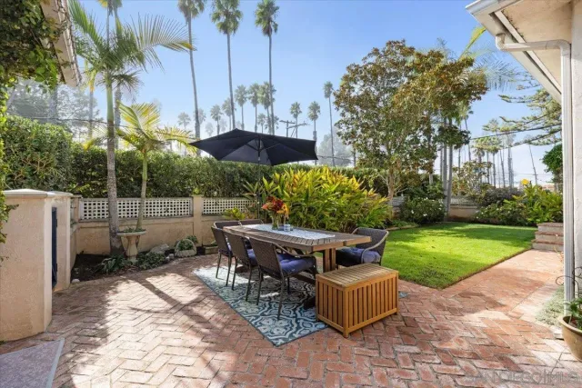 a view of a backyard with table and chairs potted plants