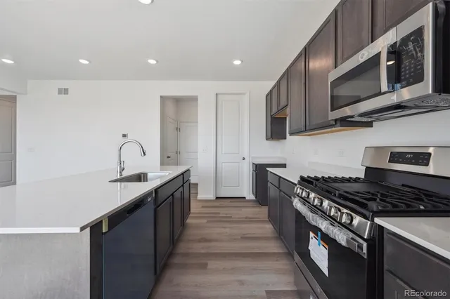 a kitchen with stainless steel appliances granite countertop a stove and a microwave