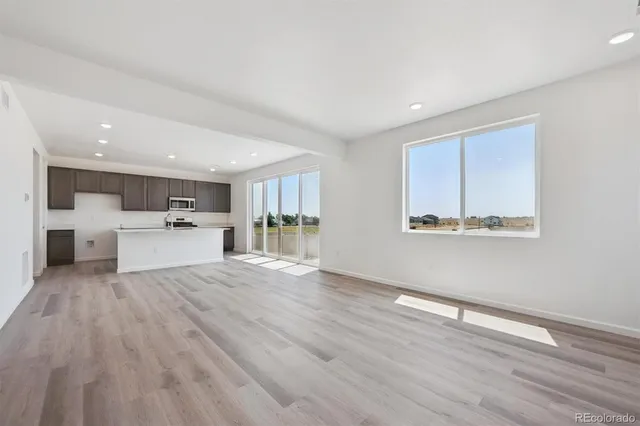 a view of a kitchen with wooden floor and windows