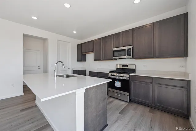 a kitchen with stainless steel appliances granite countertop a sink stove microwave and cabinets