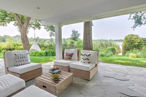 a view of a patio with couches potted plants and a big yard