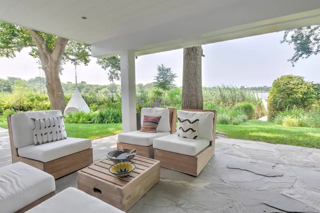 a view of a patio with couches potted plants and a big yard