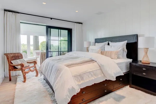 a bedroom with a bed and a large window