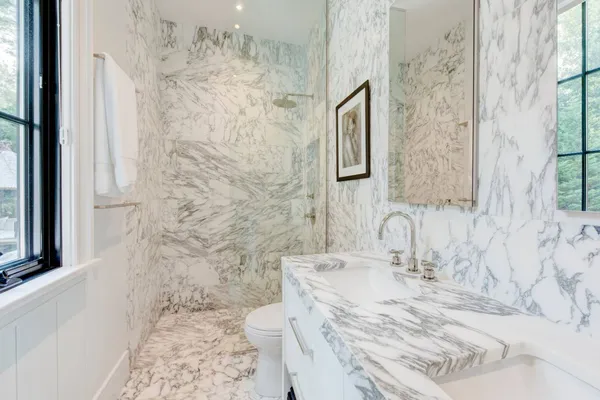 a bathroom with a granite countertop sink a toilet and shower