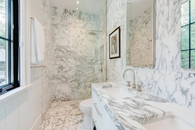a bathroom with a granite countertop sink a toilet and shower