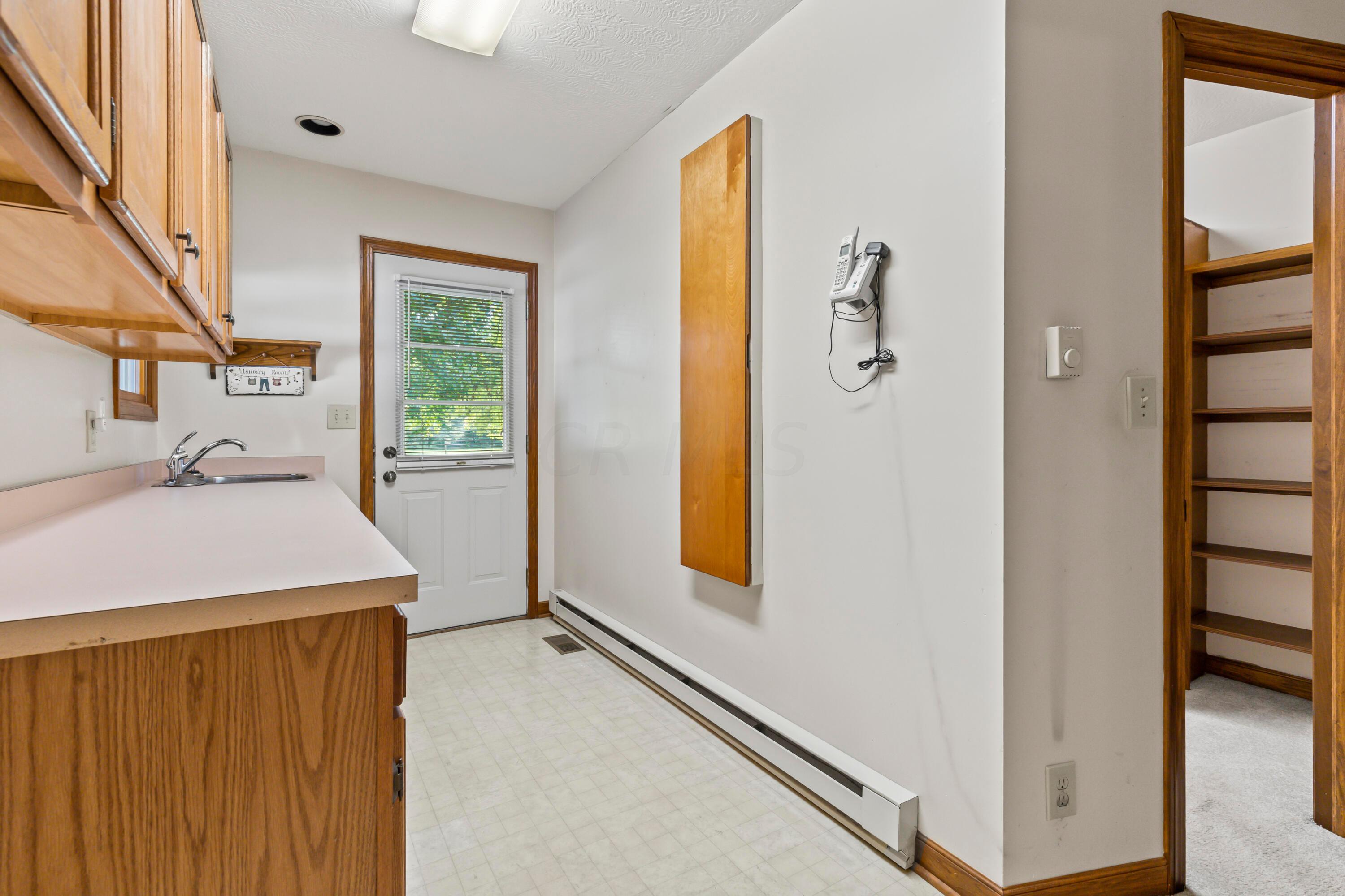 5764 Cheshire Road Galena, OH 43021 - Photo 19 of 59 • Neutral vinyl flooring
• Tan painted walls
• Wall cabinets
• Enclosed & extended vanity
• Single bowl, stainless steel
sink
• Built-in ironing board
• Electric dryer hookup
• Rear service door
• Step-in closet