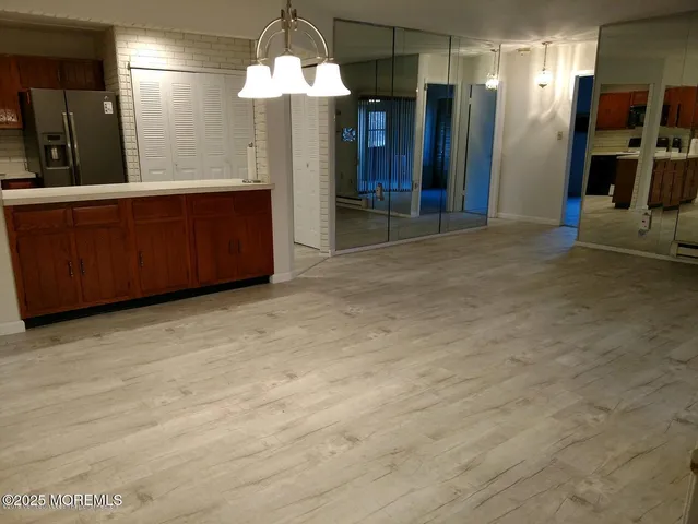 an empty room with wooden floor windows and entryway
