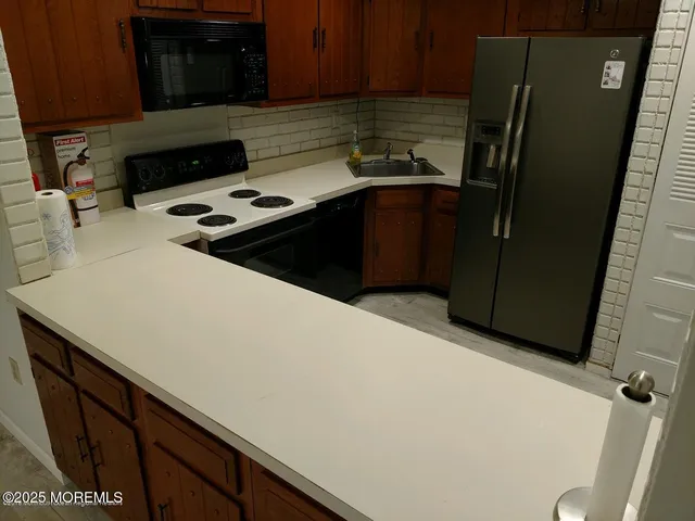 a kitchen with stainless steel appliances a refrigerator a stove a microwave a sink and cabinets