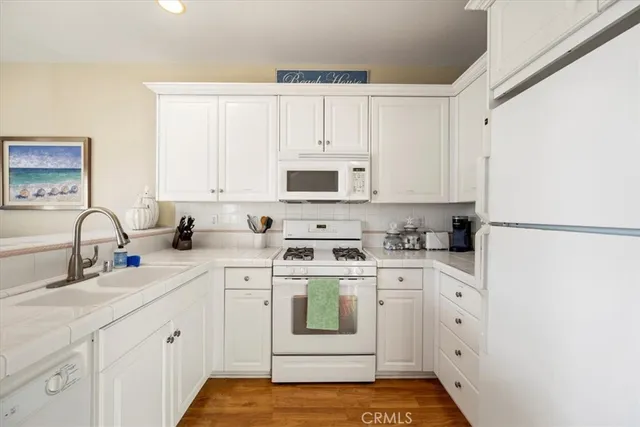 a kitchen with white cabinets and white appliances