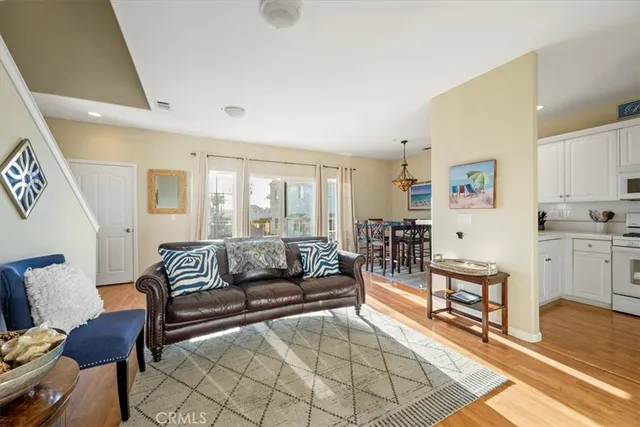 a living room with furniture and a dining table with wooden floor