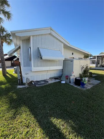 a view of a house with backyard and sitting area