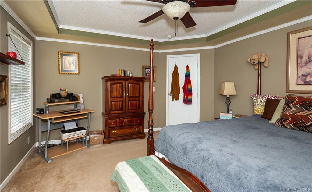 2843 Fay Jones Road Denver, NC 28037 - Photo 14 of 27 a bedroom with a bed and a chandelier